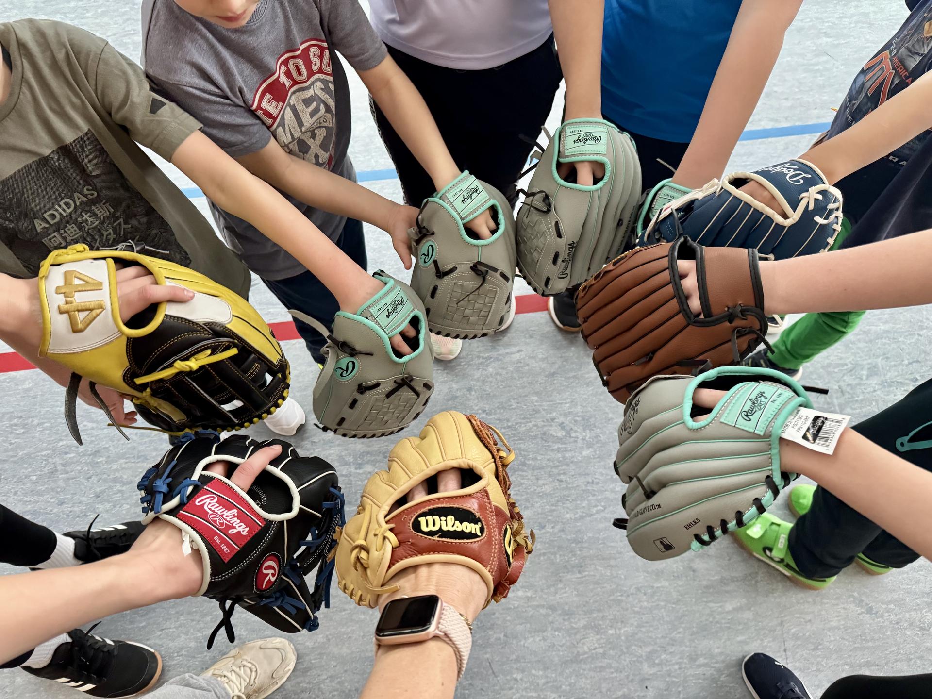 English Camp 01 Kinder halten ihre Baseball-Handschuhe in einem Kreis zusammen